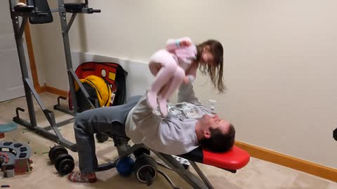 Dad gets creative by bench pressing daughter in home gym