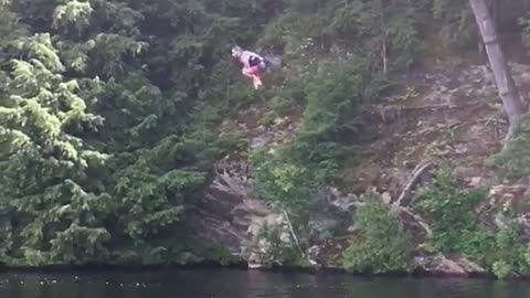 Guy does a front flip and belly flops in a lake from a ropeswing