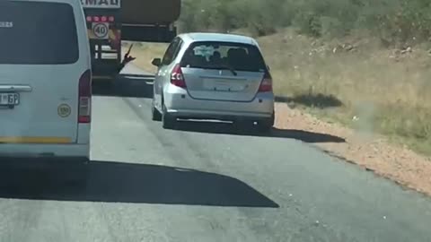 Car Attempts to Pass Truck on Narrow Road