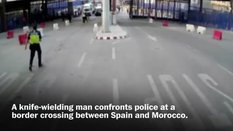 Spanish police throw traffic barrier at knife-wielding man