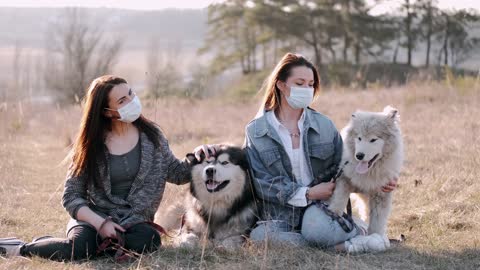 Women With Face Masks Petting Dogs