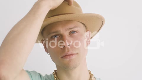 Portrait Of Young Man Putting A Hat On, Looks At Front And Then, Moves His Head