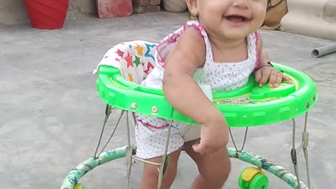 A cut baby playing in walker