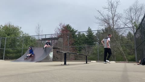 Guy Falls to the Ground Attempting a Trick on the Skate Rail