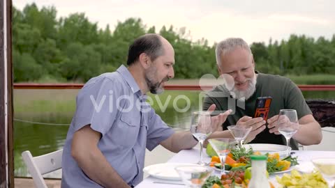 Two Men Having Dinner Or Lunch Outdoors