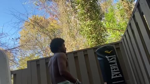 Black man harassing standing punching bag