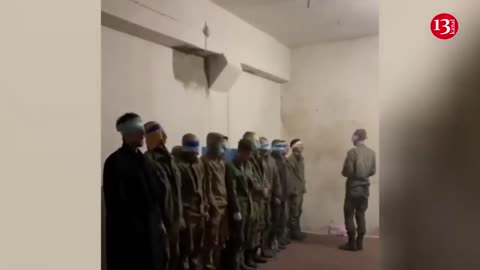 Ukrainian soldiers get around 10 captured Russian soldiers sing Ukrainian anthem