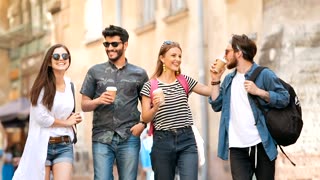 Group of friends walk on street with coffee