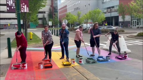 Proud Imbeciles stand in wet paint as they Paint Pride colored crosswalk.
