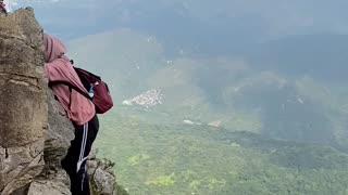 woman crossing a cliff without safety🧗🏾‍♀️