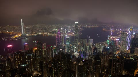 City of huge buildings with a river at night