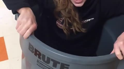 Girl in trash can tipped over