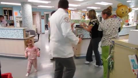 Doctors and nurses dance with sick child