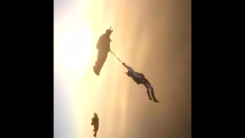 Just hanging out! Daredevil dangles by rope from wingsuit pilot in epic stunt