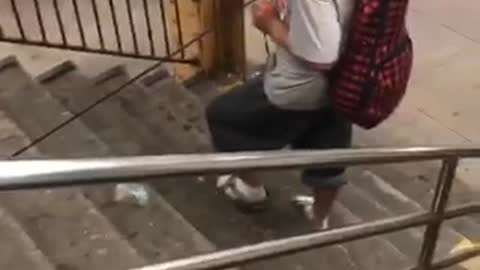 Guy pulls kitten on a leash down subway stairs
