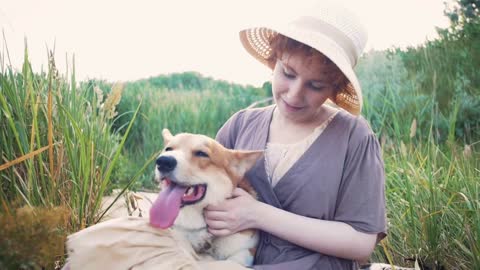Happy corgi dog with the owner girl in the park near the reed