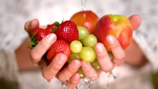 Rinsing strawberries, apples and grapes holding hands