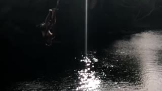 Shirtless guy faceplants in river off rope swing