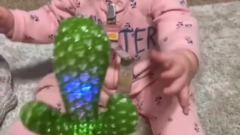 Baby and toy cactus have serious discussion