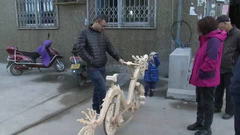Un chino fabrica una bicicleta con forma de dragón hecha de palitos de helado