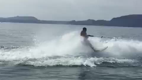 Guy stands up on jet skis and water knocks him over