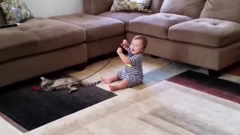 Cute baby laughing while playing with Cat
