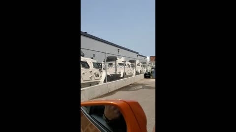 Several UN Armored trucks aligned behind a Canadian pharmaceutical building