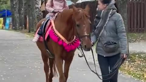 Ариша любит кататься на лошадках.