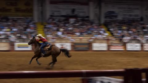 American cowgirl doing barrel racing at rodeo in Cowtown Coliseum