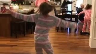 Pajama girl spins on red hoverboard in kitchen till falls