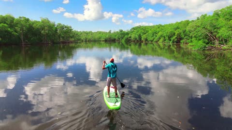 Man Paddleboarding in Placid River