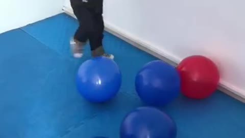 Baby kicks balloons run into wall