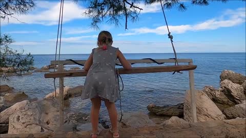 A Young Girl Playing With A Swing By The Sea Side