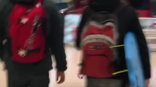 Guy carries surfboard through a mall