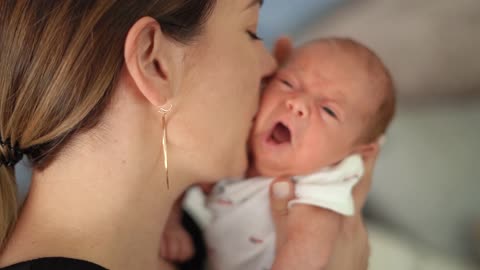Mother Kissing her Crying Baby