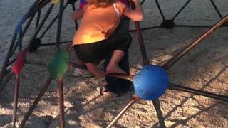 Little girl yellow climbing jungle gym dome falls forward and into wood chips