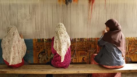 women weaving textile by hand