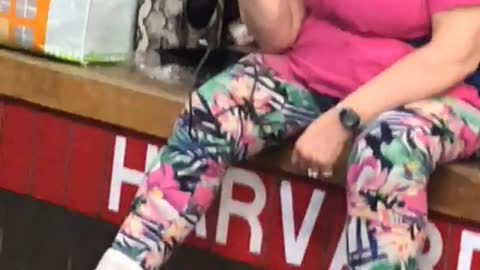 Lady pink sitting on bench subway singing
