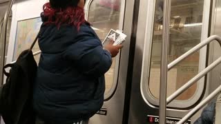 Woman putting flyers on subway ceiling