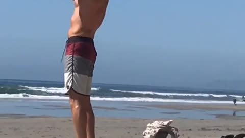 Shirtless guy beach praising the sun