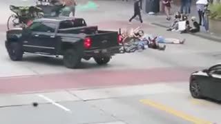 Man tosses smoke grenade into group protestors, brandishes firearm after they attack his truck