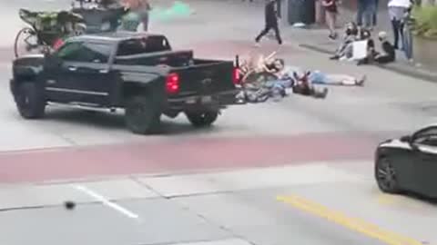 Man tosses smoke grenade into group protestors, brandishes firearm after they attack his truck
