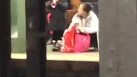 Little girl blows a toy kazoo at subway station