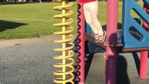 Child red shirt playground jump fail