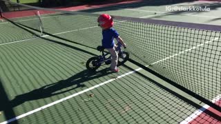Boy riding bike runs into tennis net