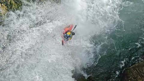 SLO MO Rider in a yellow whitewater kayak dropping a waterfal