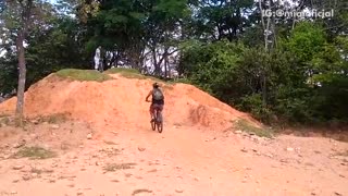Guy tries to ride bike up of dirt hill mountain fails and falls backwards