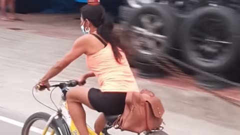 Bicyclist Balances Bottle on Head