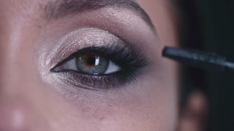 A Woman Applying Mascara To Thickens And Enhanced Her Eye Lashes