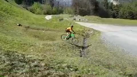 Guy yellow shirt green bike grass hill fail